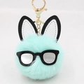 Detail of mint green plush ball keychain with black glasses and bunny ears on white background - Mint Green