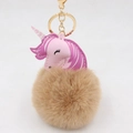 Detailed view of unicorn bag charm with pink leather head, brown fur ball, and gold clasp - Gold Keychain / Khaki