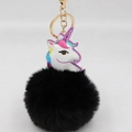 Makroaufnahme von süßem Einhorn-Lederanhänger mit schwarzem Kunstfell-Bommel und Goldring - Goldener Schlüsselanhänger / Schwarz