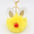 Close-up of yellow faux fur ball keychain with white leather ears and gold glitter - Bunny Ear Pom Pom Keychain / Yellow