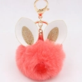 Detail of a fluffy orange-pink faux fur keychain with gold glitter rabbit ears and metal clasp - Bunny Ear Pom Pom Keychain / Orange Red
