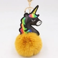 Close-up of black PU unicorn charm with yellow pom-pom and gold metal keychain - Orange