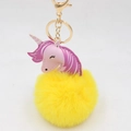 Detailed view of the pink unicorn charm and soft yellow faux fur pom pom keychain - Gold Keychain / Yellow