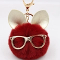 Gros plan d'un porte-clés lapin en peluche rouge foncé avec lunettes et oreilles dorées - Porte-clés Lunettes et Oreilles / Bordeaux