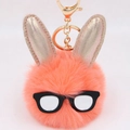 Détail d'un porte-clés lapin en peluche avec oreilles pailletées dorées et lunettes noires - Rouge Orangé