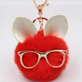 Détail d'un porte-clés pompon rouge avec oreilles de lapin dorées et lunettes chic - Porte-clés Lunettes et Oreilles / Rouge