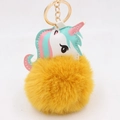 Detail of cute unicorn keychain with soft yellow pom-pom and golden metal ring - Orange