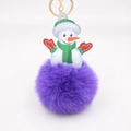 Close-up of fluffy purple snowman pompom keychain with golden metal ring detail - Purple