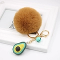 Detailed shot of brown faux fur pom pom keychain with avocado charm and gold hardware - Avocado Keychain / Coffee
