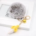 Detailed close-up of plush banana keychain with grey pompom and yellow bell charm - Two-tone Grey