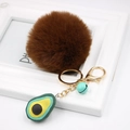 Macro detail of avocado plush keychain with brown faux fur ball and golden metal clasp - Avocado Keychain / Brown