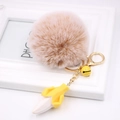 Close-up of a plush fruit keychain with yellow banana, bell and lobster clasp - Mixed Khaki