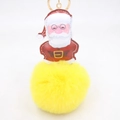 Dettaglio del ciondolo di Babbo Natale in pelle PU con grande pompon in ecopelliccia gialla - Portachiavi d'Oro / Giallo