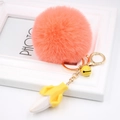 Detail of orange faux fur pompom keychain with banana charm and gold lobster clasp - Orange Red