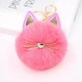 Detailed close-up of bright pink cat plush keychain with gold whiskers and fluffy fur - Watermelon red