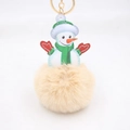 Detailed close-up of fluffy snowman pompom keychain with golden metal clasp for bags - Nude