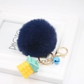Detail of blue plush ball keychain with yellow resin pineapple and gold metal lobster clasp - Navy Blue