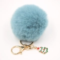Détail du porte-clés pompon en fausse fourrure bleue avec fermoir doré et charme de Noël - Bleu sarcelle