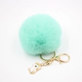 Detail eines mintgrünen Pelzimitat-Pompon-Schlüsselanhängers mit goldenem Einhorn-Anhänger - Einhorn Schlüsselanhänger / Minzgrün