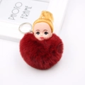 Détail d'un porte-clés pompon rouge foncé avec tête de poupée mignonne et anneau argenté - Bordeaux