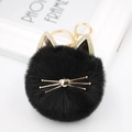 Detailed close-up of a black cat plush keychain with golden ears and metal whiskers - Black
