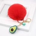 Detail of red plush faux fur pompom keychain with avocado pendant and blue bell charms - Avocado Keychain / Red