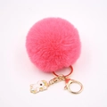 Détail du porte-clés boule de poils rose avec breloque licorne dorée et fermoir homard - Porte-clés Licorne / Rouge pastèque