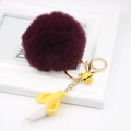Detail of creative deep purple pom pom keychain with yellow banana pendant and golden clasp - Fuschia