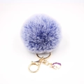 Close-up of fluffy purple pompom keychain with golden unicorn enamel pendant charm - Small Unicorn Keychain / Double Blue