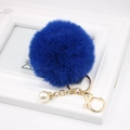 Royal blue faux fur pompom keychain with golden clasp and a white pearl charm detail - Sapphire Blue