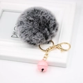 Close-up of fluffy faux rabbit fur keychain with pink bell and golden lobster clasp - Two-tone Black