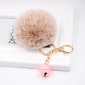 Close-up of fluffy light brown pompom keychain with golden clasp and small pink bell - Mixed Khaki