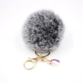 Detail of grey fluffy pompom keychain with golden metal clasp and purple unicorn charm - Small Unicorn Keychain / Two-tone Black