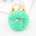 Close-up of mint green plush cat head keychain with gold ears and heart-shaped nose - Grass Green
