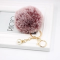 Close-up of wine red faux fur pompom keychain with gold chain and pearl accent - Dual-color Red