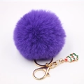 Détail du porte-clés en fourrure violette avec anneau doré et breloque sapin de Noël - Violet foncé