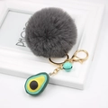 Detail view of avocado keychain with grey faux fur pompom and light green small bell - Avocado Keychain / Dark Gray