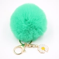 Détail du porte-clés pompon en fausse fourrure vert clair avec mousqueton doré et breloque marguerite - Vert Herbe