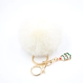 Detail of white fluffy faux fur pompom keychain with a green Christmas tree charm - Off-white