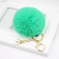 Detail of bright green faux fur pompom keychain with gold clasp and pearl accessory - Grass Green