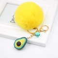 Detail of yellow plush pompom keychain with golden metal clasp and avocado charm - Avocado Keychain / Yellow