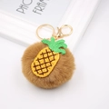 Vue détaillée du porte-clés pompon ananas marron avec fermoir doré et anneau métallique - Porte-clés Doré / Café-Ananas