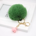 Close-up of fluffy green faux fur pompom with golden keychain and pink bell on white frame - Army Green