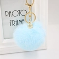 Detail of light blue faux fur keychain with a gold snowflake charm and metal ring - Light Blue
