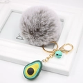 Detail of plush faux fur pompom with avocado charm and blue bell on gold keychain - Avocado Keychain / Two-tone Grey