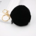Detail view of 8cm black fluffy faux fur pompom keychain with golden metal clasp and ring - Black