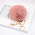 Detail of pink faux fur keychain with gold ring and white pearl charm on a frame - Dusty Pink