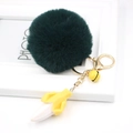 Detail of green fluffy pom pom keychain with banana charm and golden bell - Dark Green