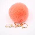 Détail d'un porte-clés pompon rose avec fermoir doré et pendentif licorne - Porte-clés Licorne / Rouge Orangé