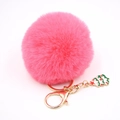 Détail du porte-clés pompon en fausse fourrure rose vif avec un charme de sapin de Noël vert - Rouge pastèque